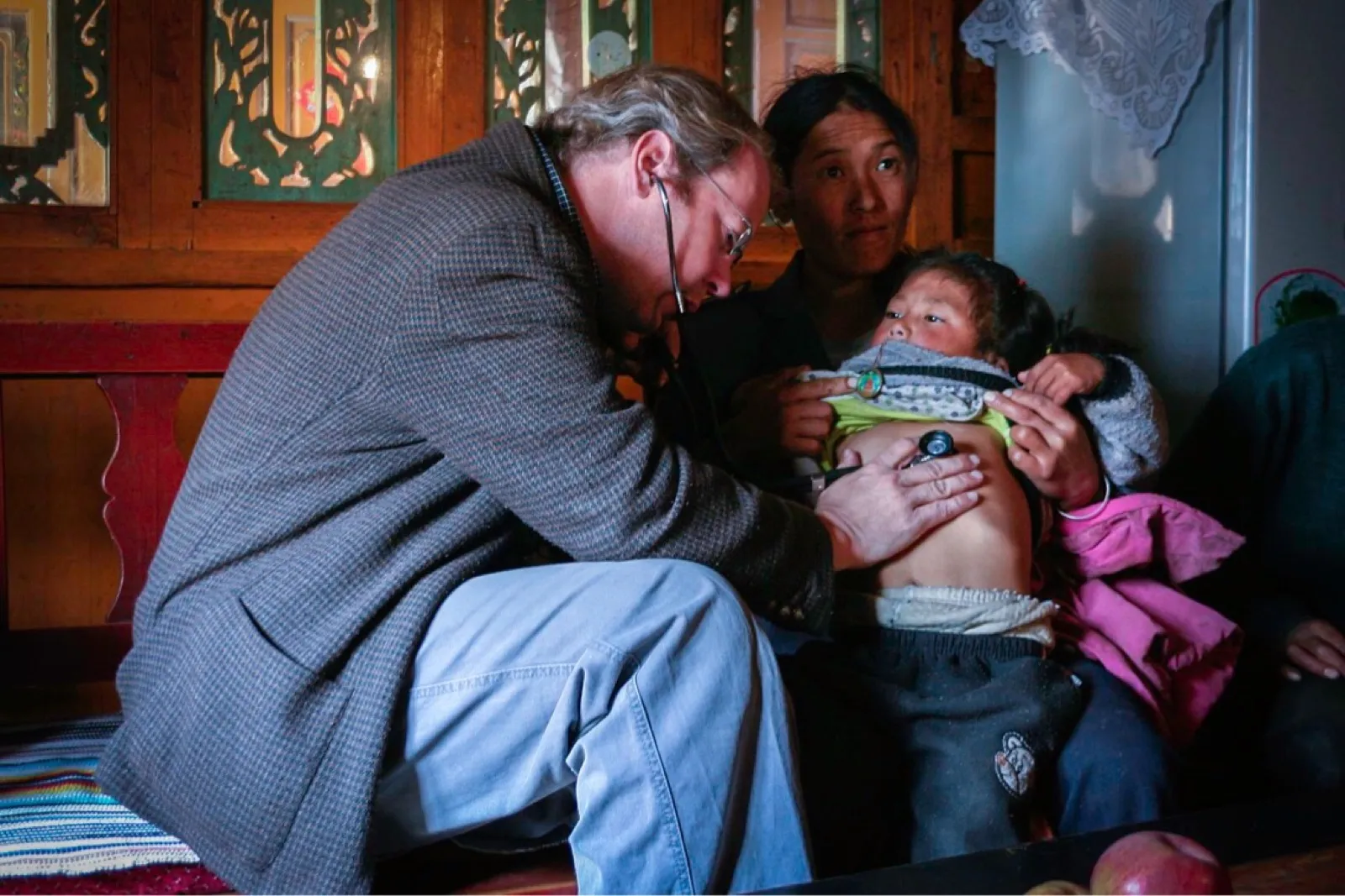 Dr. Briggs listening to a child's chest with a stethoscope