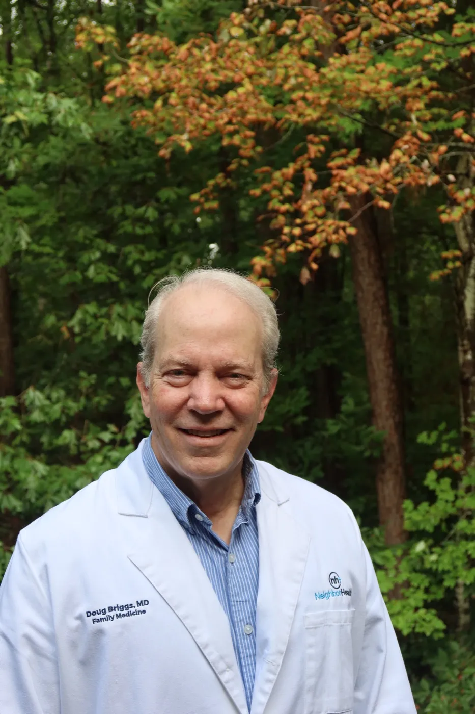Dr. Doug Briggs smiling outdoors in his white coat